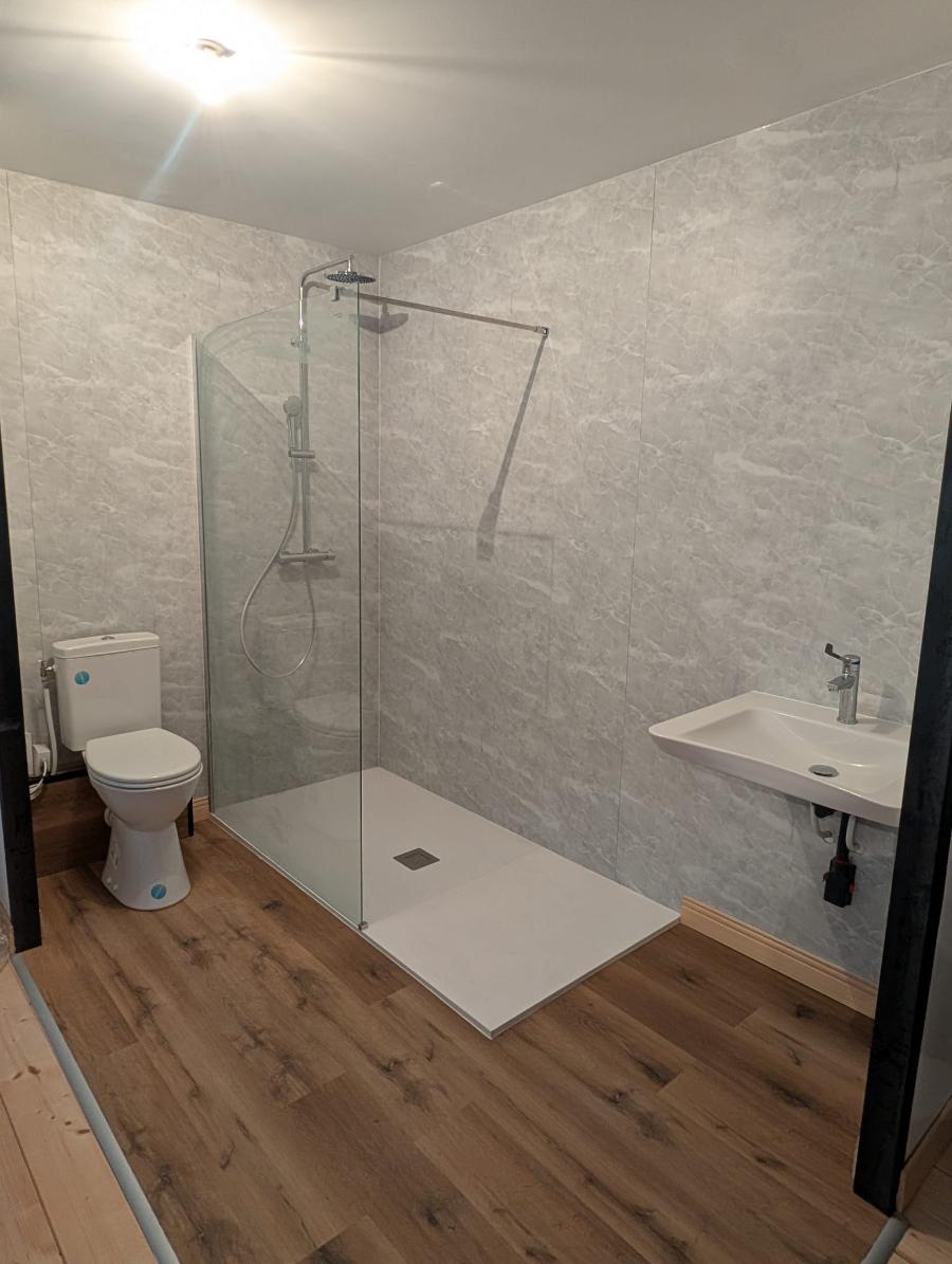 Douche de plain-pied avec receveur extra-plat, paroi fixe et mitigeur thermostatique